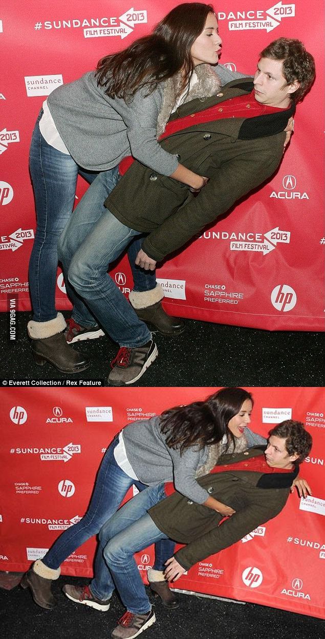 Famous actor Michael Cera is photographed on the 2013 Sundance film festival welcome mat with another celebrity women, Catalina Sandino. Cera is seen aggressively dodging a kiss from the women he is with by leaning his body back at almost 90 degrees.